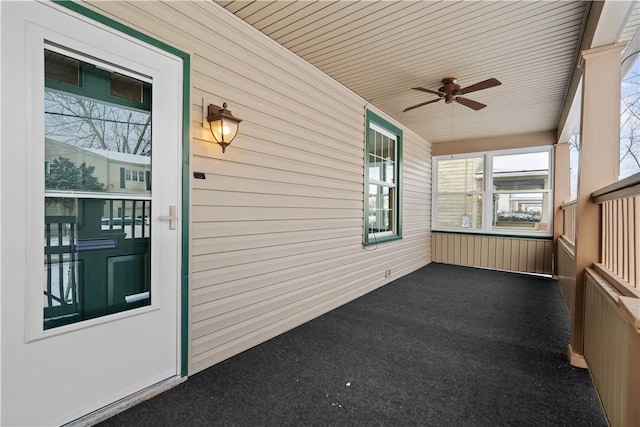 unfurnished sunroom featuring ceiling fan