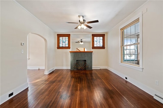 unfurnished living room featuring hardwood / wood-style floors, ceiling fan, ornamental molding, a brick fireplace, and a baseboard heating unit