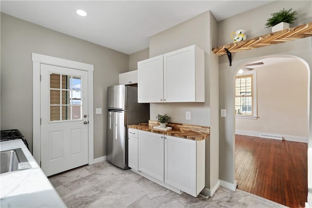 kitchen featuring sink, white cabinets, and stainless steel fridge