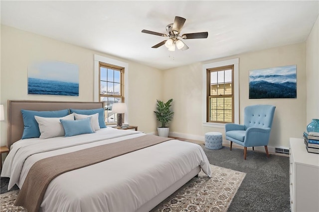 carpeted bedroom featuring ceiling fan and multiple windows