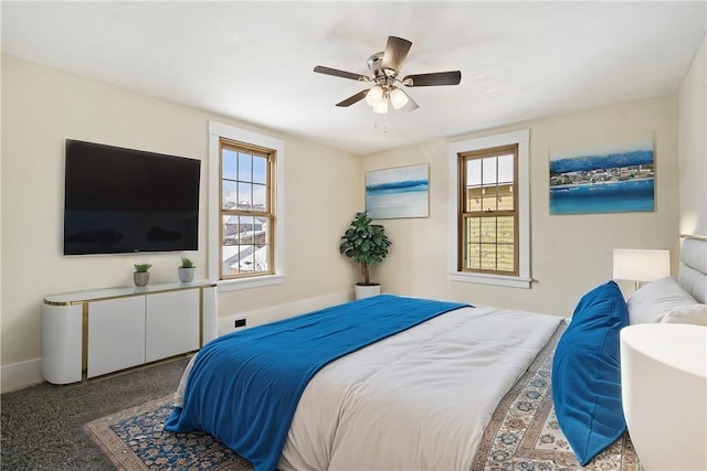 carpeted bedroom featuring multiple windows and ceiling fan