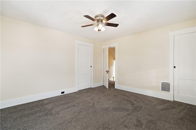 spare room with ceiling fan and dark colored carpet