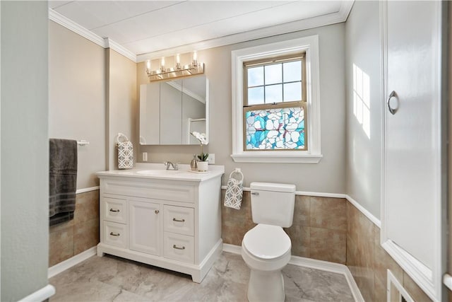 bathroom with tile walls, crown molding, vanity, and toilet