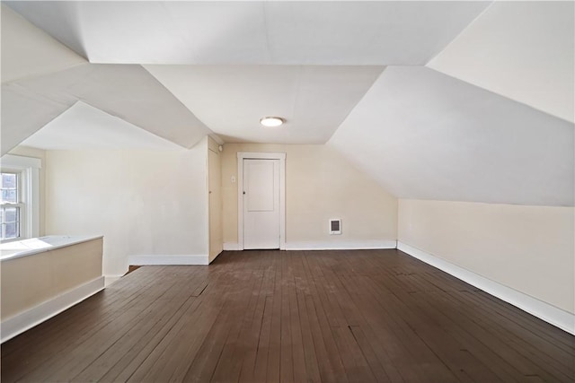 bonus room featuring dark wood-type flooring and vaulted ceiling