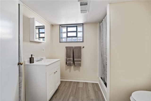 bathroom featuring toilet, a shower with shower curtain, wood-type flooring, and vanity