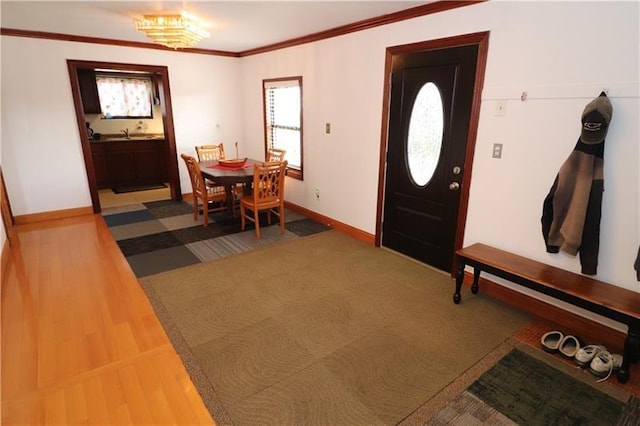 foyer entrance with hardwood / wood-style flooring, a notable chandelier, and ornamental molding