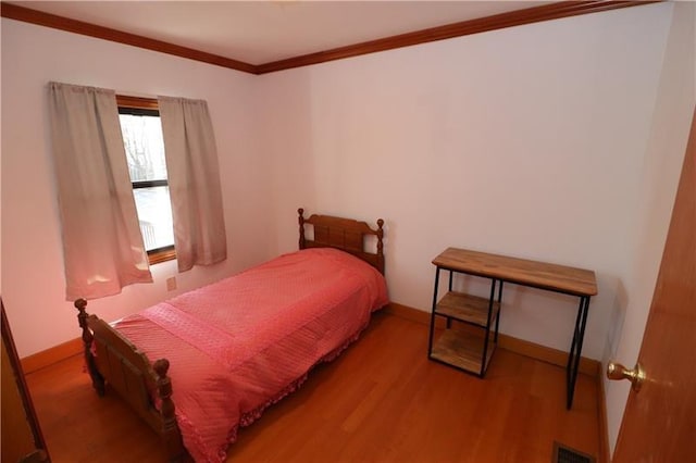 bedroom featuring light hardwood / wood-style floors and crown molding