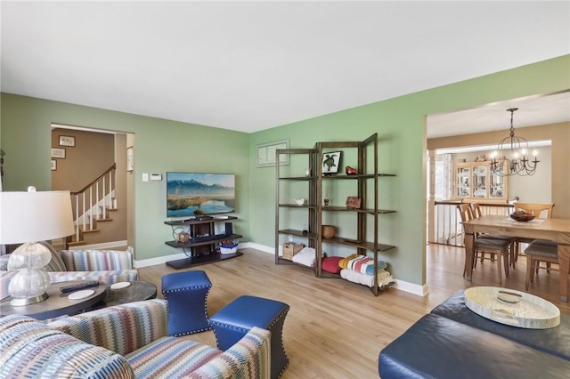 living room with a notable chandelier and light hardwood / wood-style flooring