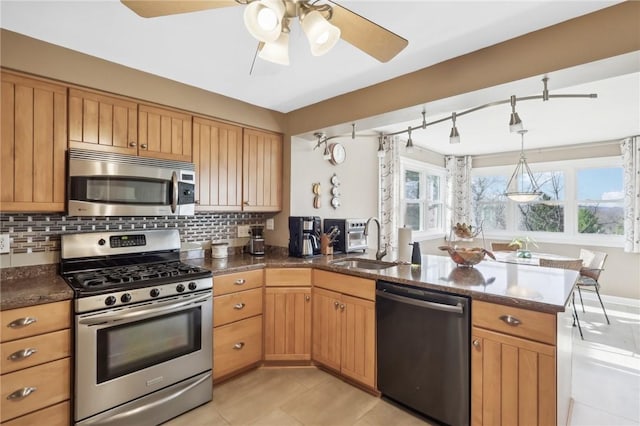 kitchen featuring sink, light tile patterned floors, kitchen peninsula, decorative backsplash, and appliances with stainless steel finishes