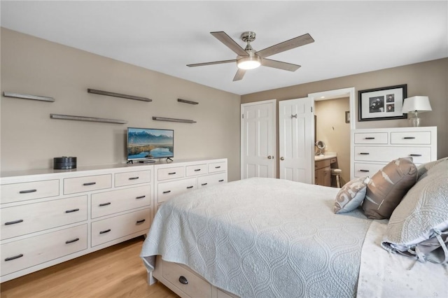 bedroom featuring ceiling fan, light wood-type flooring, and ensuite bath