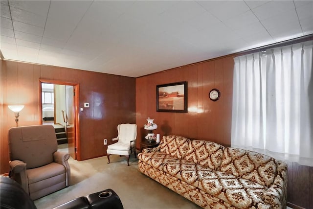 carpeted living room featuring wood walls