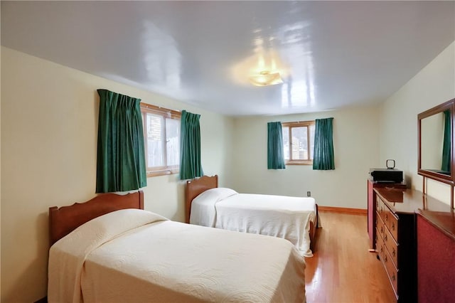 bedroom with light wood-type flooring and multiple windows