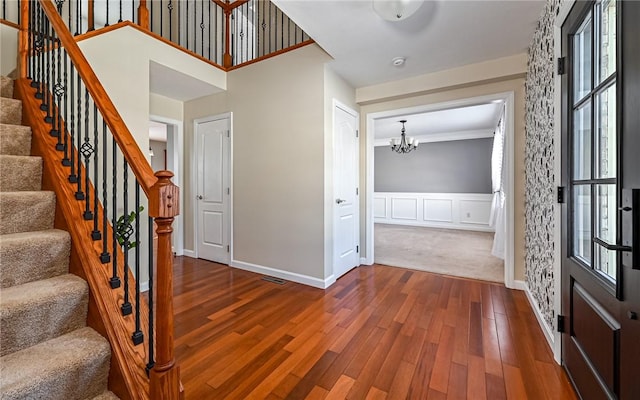 entrance foyer featuring an inviting chandelier, hardwood / wood-style flooring, and plenty of natural light