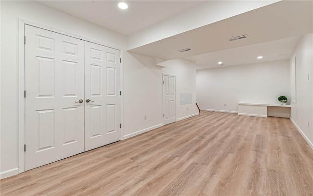 basement with light hardwood / wood-style flooring