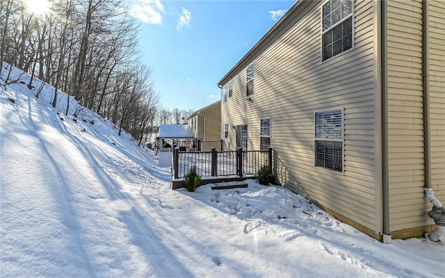 view of snowy exterior featuring a wooden deck