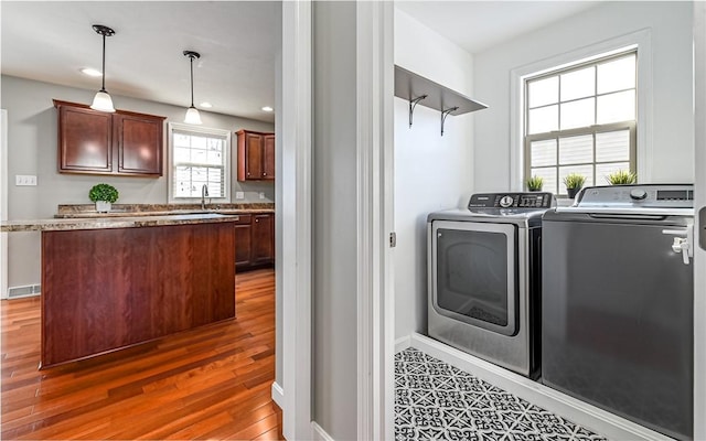 laundry room with washer and dryer and dark hardwood / wood-style flooring