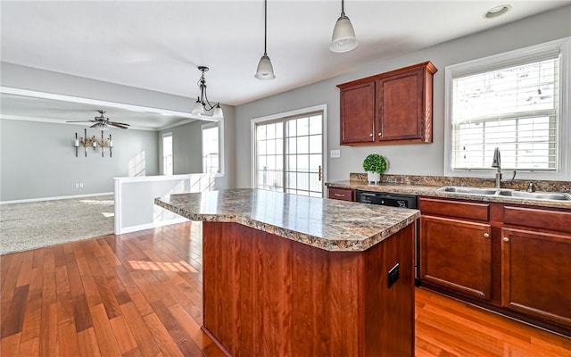 kitchen with sink, decorative light fixtures, black dishwasher, ceiling fan, and a kitchen island