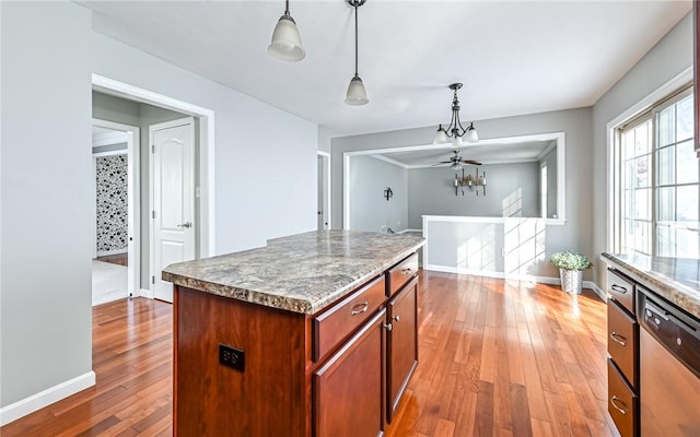 kitchen featuring hanging light fixtures, light wood-type flooring, dishwasher, and a kitchen island