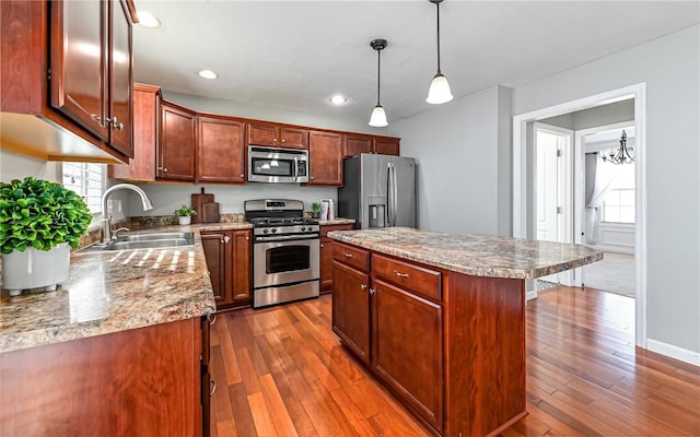 kitchen with sink, a center island, pendant lighting, a notable chandelier, and appliances with stainless steel finishes