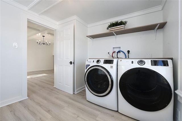 laundry room with washing machine and dryer, a notable chandelier, crown molding, and light hardwood / wood-style floors