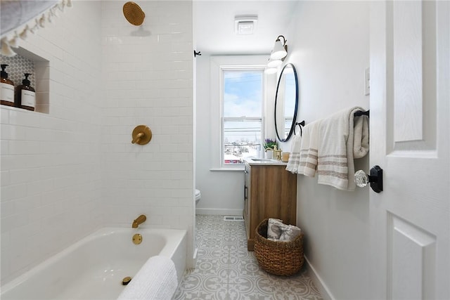 full bathroom featuring tiled shower / bath, tile patterned floors, vanity, and toilet