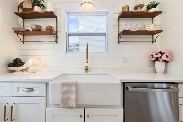 kitchen with sink, white cabinetry, dishwasher, and light stone countertops