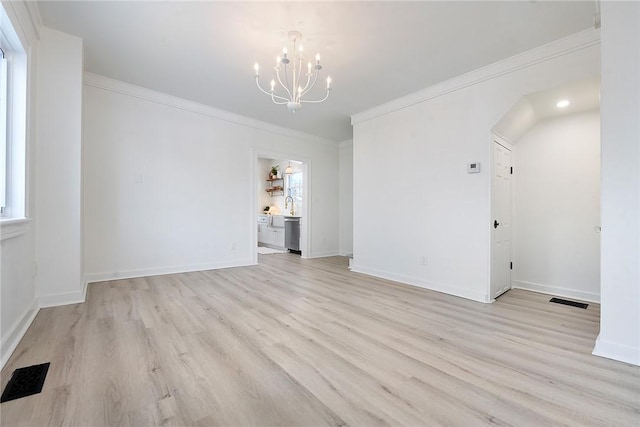 unfurnished room with an inviting chandelier, light wood-type flooring, and ornamental molding