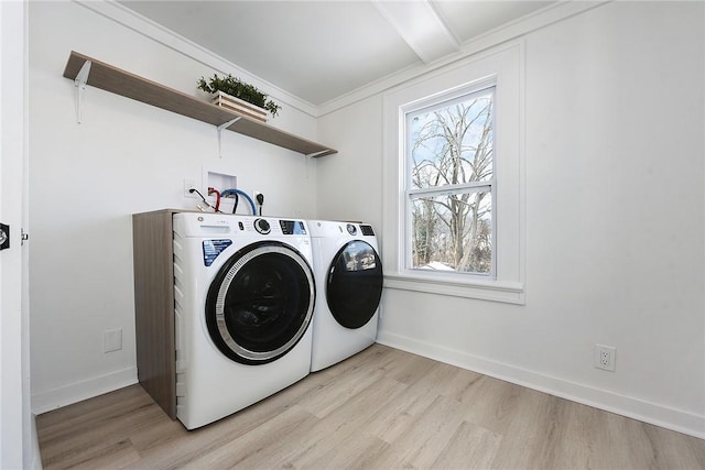 laundry area with a wealth of natural light, separate washer and dryer, crown molding, and light hardwood / wood-style flooring