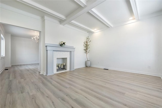 unfurnished living room with coffered ceiling, light wood-type flooring, ornamental molding, a notable chandelier, and beam ceiling