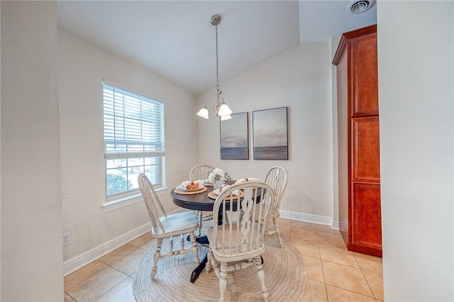 dining space featuring light tile patterned flooring, vaulted ceiling, and a chandelier