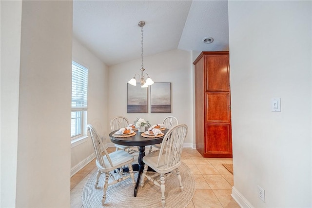 tiled dining space featuring a healthy amount of sunlight, an inviting chandelier, and lofted ceiling