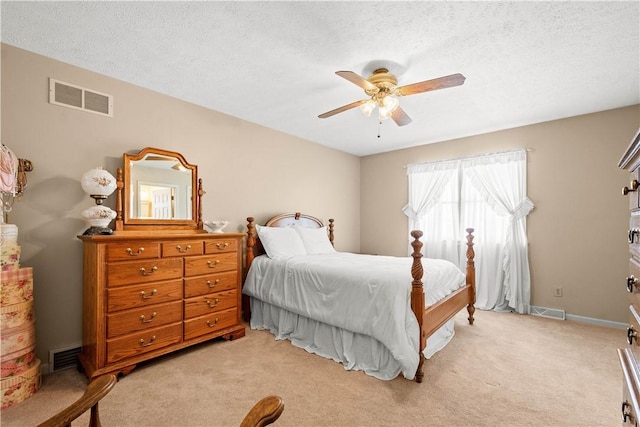 carpeted bedroom featuring a textured ceiling and ceiling fan