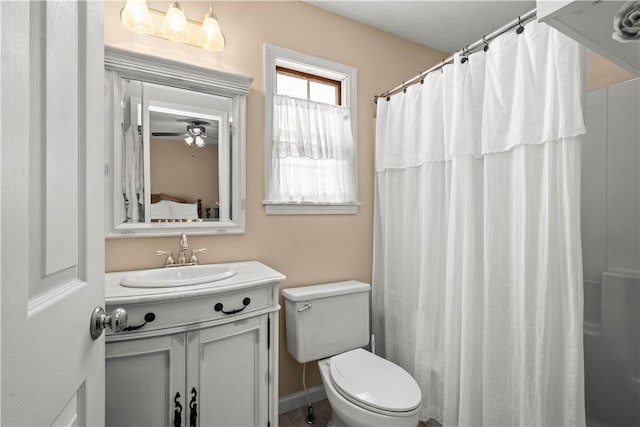 bathroom with toilet, ceiling fan, walk in shower, and vanity