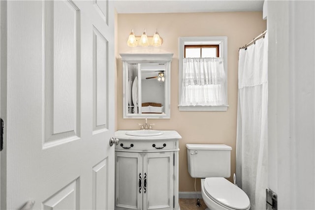 bathroom featuring toilet, vanity, and ceiling fan