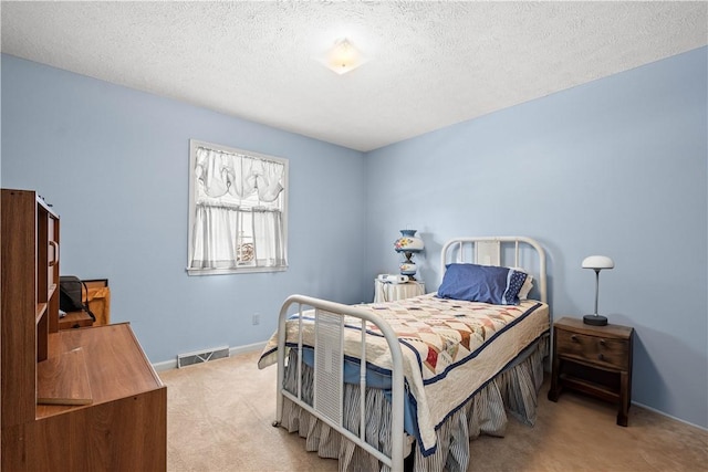 bedroom featuring a textured ceiling and light carpet