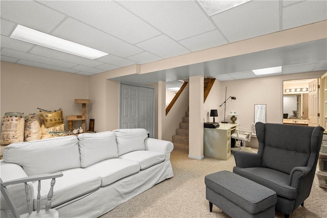 carpeted living room with a paneled ceiling