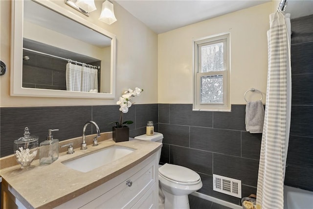 bathroom featuring tile walls, walk in shower, vanity, and toilet