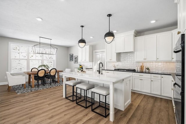 kitchen featuring white cabinetry, hanging light fixtures, and sink