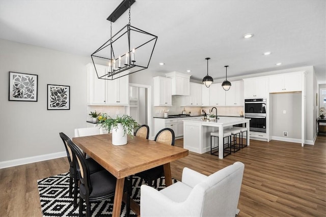 dining space featuring an inviting chandelier, dark hardwood / wood-style floors, and sink