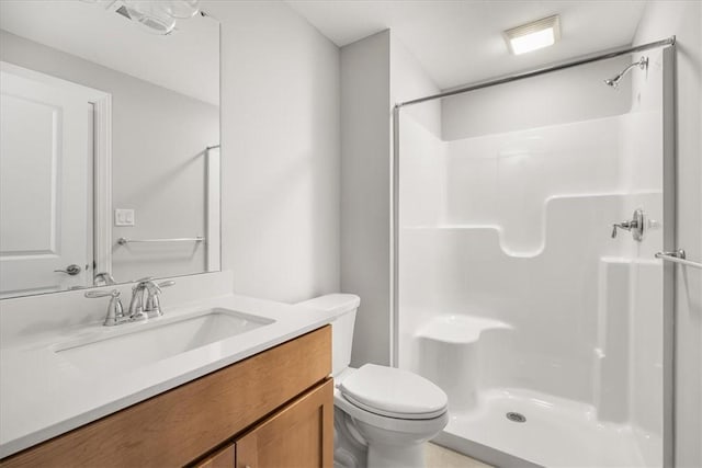 bathroom featuring vanity, toilet, and a shower