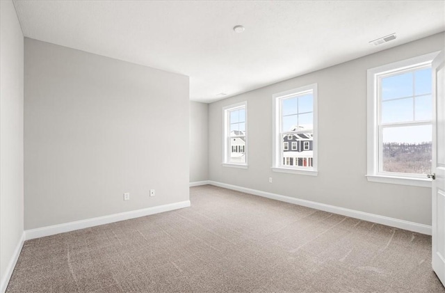 carpeted spare room featuring a healthy amount of sunlight