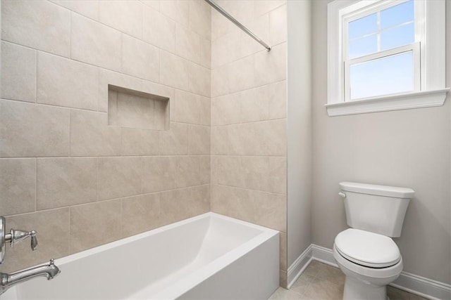 bathroom featuring tiled shower / bath combo, tile patterned flooring, and toilet