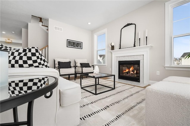 living room featuring a high end fireplace and a wealth of natural light