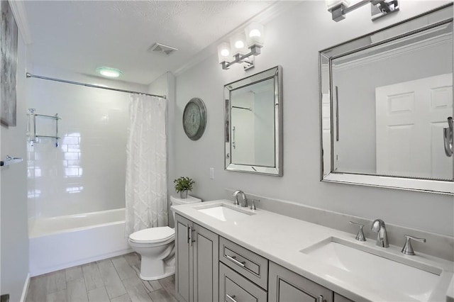 full bathroom featuring shower / bath combination with curtain, vanity, toilet, crown molding, and a textured ceiling