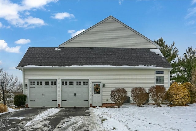 view of snowy exterior featuring a garage