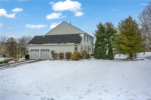 view of snow covered exterior with a garage