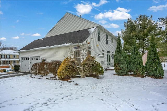 view of snow covered exterior with a garage