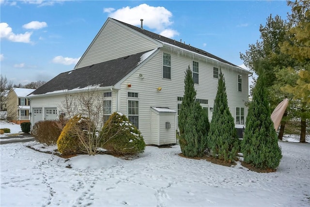 view of snowy exterior with a garage