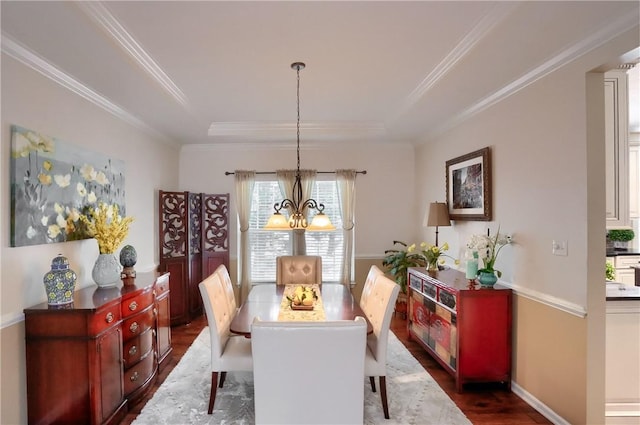 dining area featuring crown molding, dark hardwood / wood-style floors, an inviting chandelier, and a tray ceiling