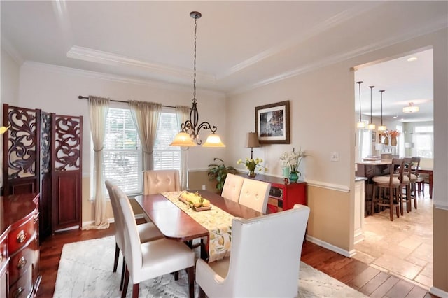 dining area featuring crown molding, a notable chandelier, and a tray ceiling